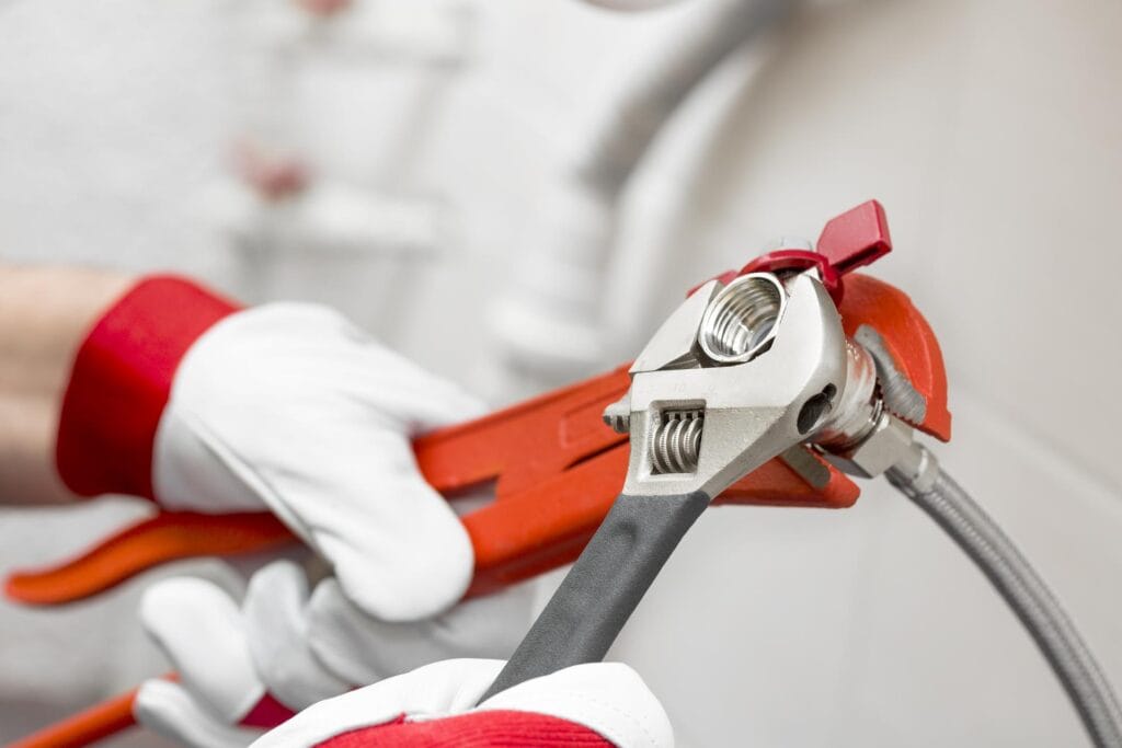 Plumber holding pipe wrenches for an emergency repair in Pensacola