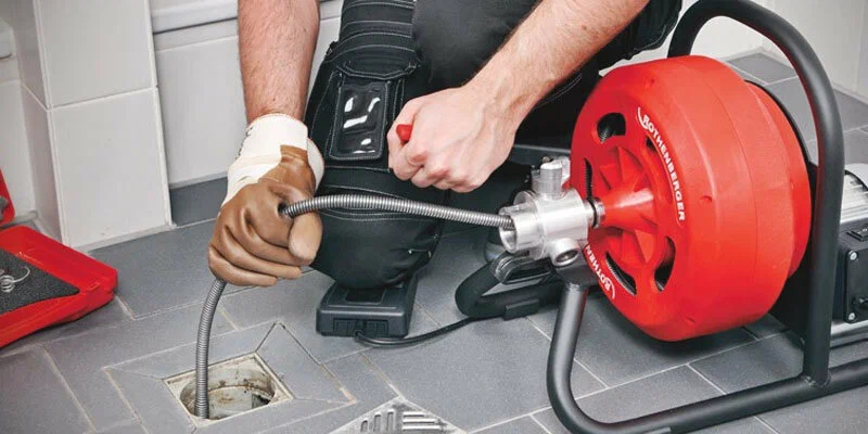 Plumber using a drain-cleaning machine in Pensacola