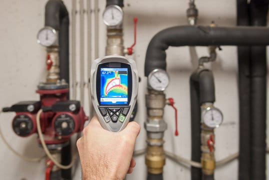 Plumber using a thermal imaging camera to inspect pipes in Pensacola