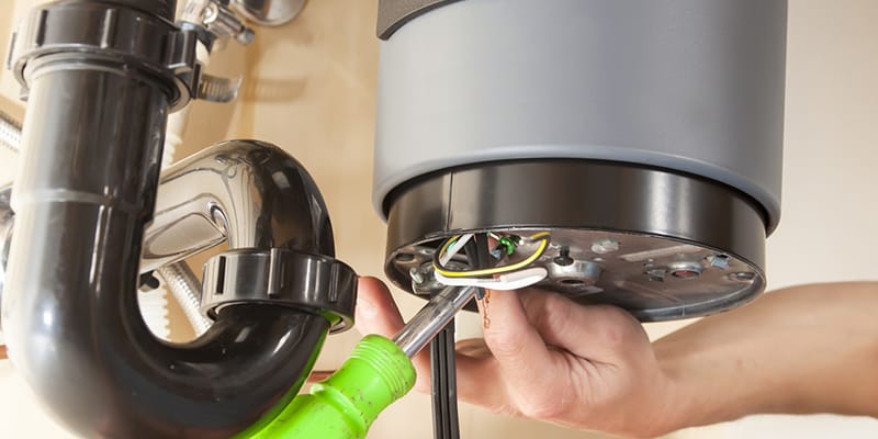 Technician repairing the heating element of a water heater in Pensacola
