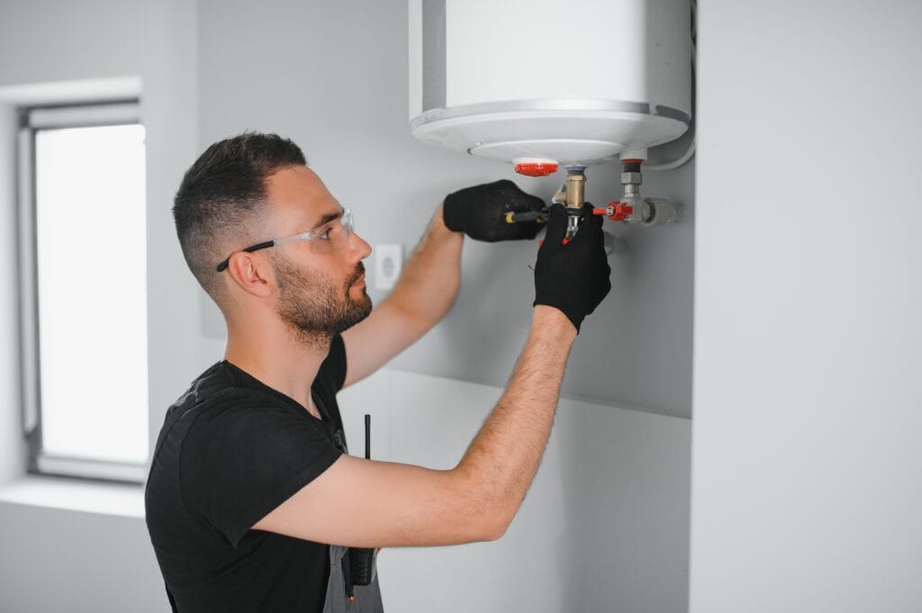 Technician performing water heater maintenance in Pensacola