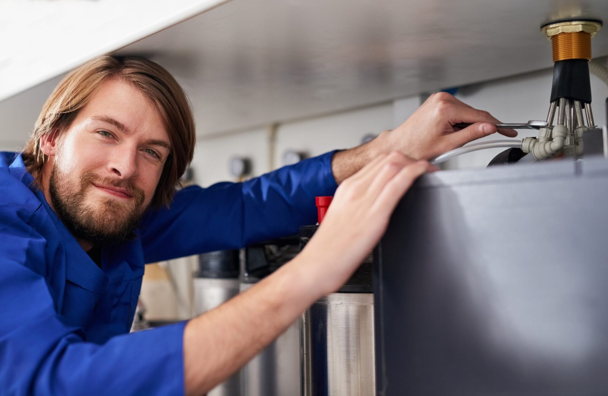 Technician servicing a residential water heater tank in Pensacola